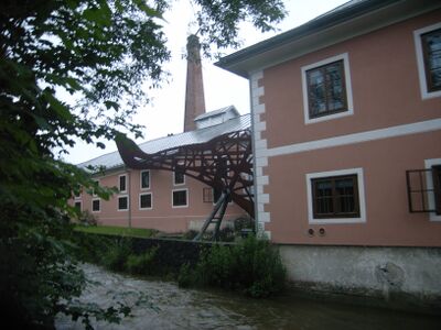 an Stelle des einstigen sechs Meter großen Wasserrades fertigte der Künstler W. M. Pühringer einen überdimensionierten Rostbarsch, dessen Kopf im Gebäude steckt