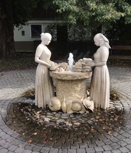 Gemüse-Bäuerinnen-Denkmal mit Brunnen bei der Kapelle